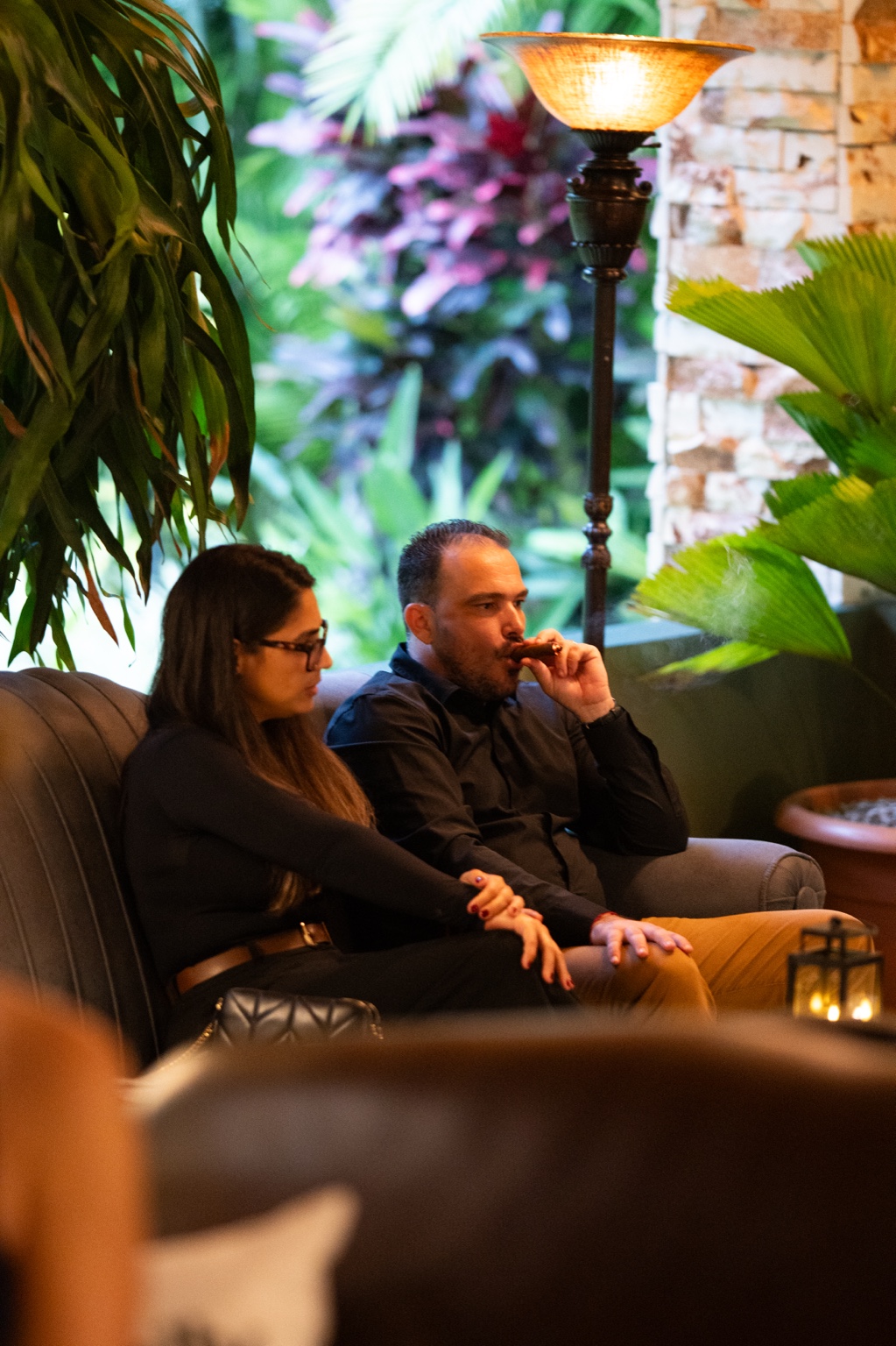 Visitantes en un rincón del lounge junto a la vegetación tropical